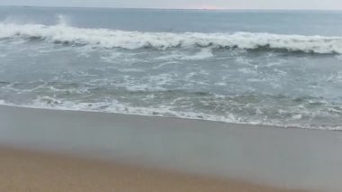 Kuzey Denizi üzerinde soğuk fırtınalı dalgalar ve bulutlar. Kuzey sahilinde kumlu bir sahilde büyük bir okyanus dalgası, beyaz kumlu tropik cennet plajı..