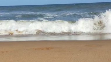 Kuzey Denizi üzerinde soğuk fırtınalı dalgalar ve bulutlar. Kuzey sahilinde kumlu bir sahilde büyük bir okyanus dalgası, beyaz kumlu tropik cennet plajı..