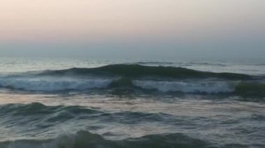 Kuzey Denizi üzerinde soğuk fırtınalı dalgalar ve bulutlar. Kuzey sahilinde kumlu bir sahilde büyük bir okyanus dalgası, beyaz kumlu tropik cennet plajı..