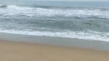 Sabahın erken saatlerinde deniz kıyısında, mavi dalgalar akıyor. Renkli kış gündoğumu. Soğuk fırtınalı dalgalar ve Baltık Denizi üzerindeki bulutlar, yere vuran altın deniz dalgaları. Manzara okyanusu