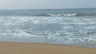 Sabahın erken saatlerinde deniz kıyısında, mavi dalgalar akıyor. Renkli kış gündoğumu. Soğuk fırtınalı dalgalar ve Baltık Denizi üzerindeki bulutlar, yere vuran altın deniz dalgaları. Manzara okyanusu