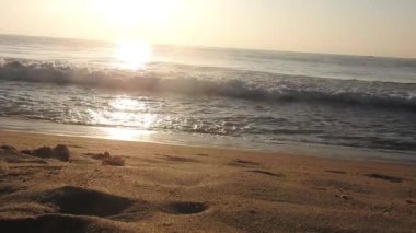 Güneşin doğuşunda balıkçıyla birlikte teknenin silueti Horizon Sunrise sahilinde güzel bir gün doğumu. Okyanus ve altın güneş doğuyor, parlak altın arka plan. Güneşin batışında dramatik bulutlu gökyüzünün olduğu güzel manzara. turuncu 