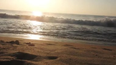 Güneşin doğuşunda balıkçıyla birlikte teknenin silueti Horizon Sunrise sahilinde güzel bir gün doğumu. Okyanus ve altın güneş doğuyor, parlak altın arka plan. Güneşin batışında dramatik bulutlu gökyüzünün olduğu güzel manzara. turuncu 