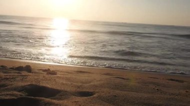 Güneşin doğuşunda balıkçıyla birlikte teknenin silueti Horizon Sunrise sahilinde güzel bir gün doğumu. Okyanus ve altın güneş doğuyor, parlak altın arka plan. Güneşin batışında dramatik bulutlu gökyüzünün olduğu güzel manzara. turuncu 