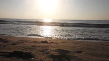 Güneşin doğuşunda balıkçıyla birlikte teknenin silueti Horizon Sunrise sahilinde güzel bir gün doğumu. Okyanus ve altın güneş doğuyor, parlak altın arka plan. Güneşin batışında dramatik bulutlu gökyüzünün olduğu güzel manzara. turuncu 