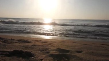 Güneşin doğuşunda balıkçıyla birlikte teknenin silueti Horizon Sunrise sahilinde güzel bir gün doğumu. Okyanus ve altın güneş doğuyor, parlak altın arka plan. Güneşin batışında dramatik bulutlu gökyüzünün olduğu güzel manzara. turuncu 