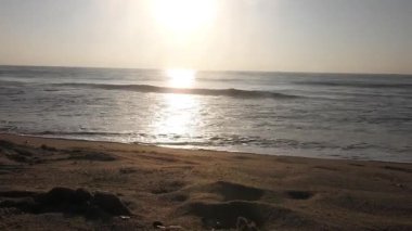 Güneşin doğuşunda balıkçıyla birlikte teknenin silueti Horizon Sunrise sahilinde güzel bir gün doğumu. Okyanus ve altın güneş doğuyor, parlak altın arka plan. Güneşin batışında dramatik bulutlu gökyüzünün olduğu güzel manzara. turuncu 