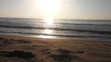 Güneşin doğuşunda balıkçıyla birlikte teknenin silueti Horizon Sunrise sahilinde güzel bir gün doğumu. Okyanus ve altın güneş doğuyor, parlak altın arka plan. Güneşin batışında dramatik bulutlu gökyüzünün olduğu güzel manzara. turuncu 