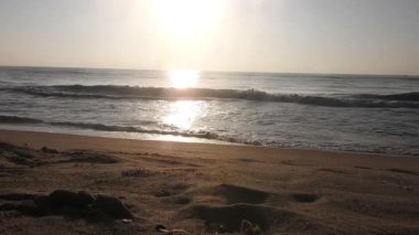 Güneşin doğuşunda balıkçıyla birlikte teknenin silueti Horizon Sunrise sahilinde güzel bir gün doğumu. Okyanus ve altın güneş doğuyor, parlak altın arka plan. Güneşin batışında dramatik bulutlu gökyüzünün olduğu güzel manzara. turuncu 