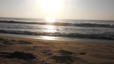 Güneşin doğuşunda balıkçıyla birlikte teknenin silueti Horizon Sunrise sahilinde güzel bir gün doğumu. Okyanus ve altın güneş doğuyor, parlak altın arka plan. Güneşin batışında dramatik bulutlu gökyüzünün olduğu güzel manzara. turuncu 