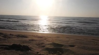 Güneşin doğuşunda balıkçıyla birlikte teknenin silueti Horizon Sunrise sahilinde güzel bir gün doğumu. Okyanus ve altın güneş doğuyor, parlak altın arka plan. Güneşin batışında dramatik bulutlu gökyüzünün olduğu güzel manzara. turuncu 