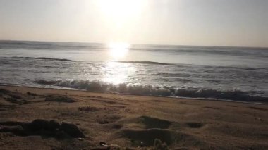 Güneşin doğuşunda balıkçıyla birlikte teknenin silueti Horizon Sunrise sahilinde güzel bir gün doğumu. Okyanus ve altın güneş doğuyor, parlak altın arka plan. Güneşin batışında dramatik bulutlu gökyüzünün olduğu güzel manzara. turuncu 