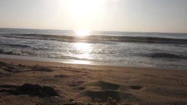 Horizon Sunrise plajında güzel bir gün doğumu. Okyanus ve altın güneş doğuyor, parlak altın arka plan. Güneşin batışında dramatik bulutlu gökyüzünün olduğu güzel manzara. turuncu gün batımı. Fırtınalı bulutlu mavi gökyüzü ile güzel bir video. 