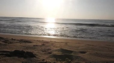 Horizon Sunrise plajında güzel bir gün doğumu. Okyanus ve altın güneş doğuyor, parlak altın arka plan. Güneşin batışında dramatik bulutlu gökyüzünün olduğu güzel manzara. turuncu gün batımı. Fırtınalı bulutlu mavi gökyüzü ile güzel bir video. 