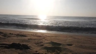Horizon Sunrise plajında güzel bir gün doğumu. Okyanus ve altın güneş doğuyor, parlak altın arka plan. Güneşin batışında dramatik bulutlu gökyüzünün olduğu güzel manzara. turuncu gün batımı. Fırtınalı bulutlu mavi gökyüzü ile güzel bir video. 