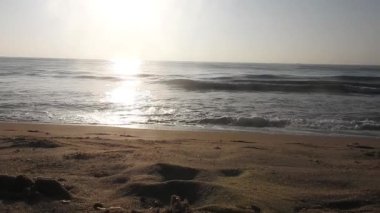 Horizon Sunrise plajında güzel bir gün doğumu. Okyanus ve altın güneş doğuyor, parlak altın arka plan. Güneşin batışında dramatik bulutlu gökyüzünün olduğu güzel manzara. turuncu gün batımı. Fırtınalı bulutlu mavi gökyüzü ile güzel bir video. 