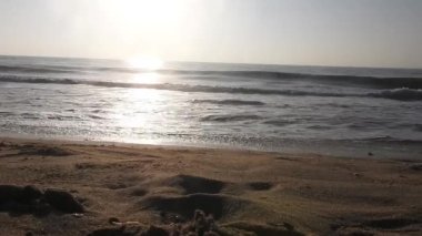 Horizon Sunrise plajında güzel bir gün doğumu. Okyanus ve altın güneş doğuyor, parlak altın arka plan. Güneşin batışında dramatik bulutlu gökyüzünün olduğu güzel manzara. turuncu gün batımı. Fırtınalı bulutlu mavi gökyüzü ile güzel bir video. 