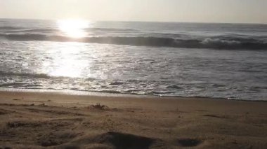 Horizon Sunrise plajında güzel bir gün doğumu. Okyanus ve altın güneş doğuyor, parlak altın arka plan. Güneşin batışında dramatik bulutlu gökyüzünün olduğu güzel manzara. turuncu gün batımı. Fırtınalı bulutlu mavi gökyüzü ile güzel bir video. 