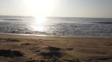 Horizon Sunrise plajında güzel bir gün doğumu. Okyanus ve altın güneş doğuyor, parlak altın arka plan. Güneşin batışında dramatik bulutlu gökyüzünün olduğu güzel manzara. turuncu gün batımı. Fırtınalı bulutlu mavi gökyüzü ile güzel bir video. 