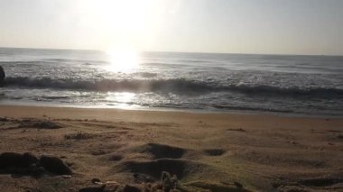 Horizon Sunrise plajında güzel bir gün doğumu. Okyanus ve altın güneş doğuyor, parlak altın arka plan. Güneşin batışında dramatik bulutlu gökyüzünün olduğu güzel manzara. turuncu gün batımı. Fırtınalı bulutlu mavi gökyüzü ile güzel bir video. 