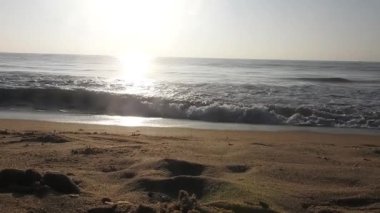 Horizon Sunrise plajında güzel bir gün doğumu. Okyanus ve altın güneş doğuyor, parlak altın arka plan. Güneşin batışında dramatik bulutlu gökyüzünün olduğu güzel manzara. turuncu gün batımı. Fırtınalı bulutlu mavi gökyüzü ile güzel bir video. 