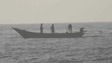Güneşin doğuşunda balıkçıyla birlikte teknenin silueti Horizon Sunrise sahilinde güzel bir gün doğumu. Okyanus ve altın güneş doğuyor, parlak altın arka plan. Gün batımı. Gün batımında denizde balıkçı tekneleri. Balıkçı teknesinin gökyüzü silueti.. 