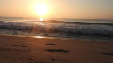 Horizon Sunrise plajında güzel bir gün doğumu. Okyanus ve altın güneş doğuyor, parlak altın arka plan. Güneşin batışında dramatik bulutlu gökyüzünün olduğu güzel manzara. Turuncu gün batımı, teknenin gölgesini denizdeki balıkçıyla vurdu. 