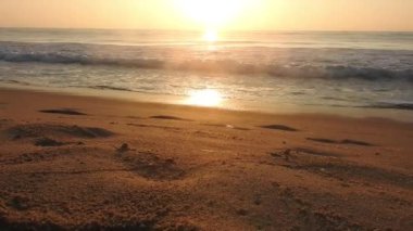 Horizon Sunrise plajında güzel bir gün doğumu. Okyanus ve altın güneş doğuyor, parlak altın arka plan. Güneşin batışında dramatik bulutlu gökyüzünün olduğu güzel manzara. Turuncu gün batımı, teknenin gölgesini denizdeki balıkçıyla vurdu. 