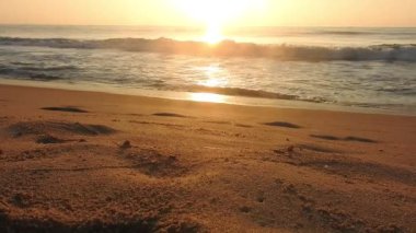 Horizon Sunrise plajında güzel bir gün doğumu. Okyanus ve altın güneş doğuyor, parlak altın arka plan. Güneşin batışında dramatik bulutlu gökyüzünün olduğu güzel manzara. Turuncu gün batımı, teknenin gölgesini denizdeki balıkçıyla vurdu. 