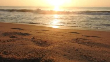 Horizon Sunrise plajında güzel bir gün doğumu. Okyanus ve altın güneş doğuyor, parlak altın arka plan. Güneşin batışında dramatik bulutlu gökyüzünün olduğu güzel manzara. Turuncu gün batımı, teknenin gölgesini denizdeki balıkçıyla vurdu. 