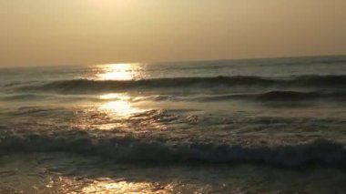 Renkli kış gündoğumu. Soğuk fırtınalı dalgalar ve Baltık Denizi üzerindeki bulutlar manzara videosunda. Tropikal bir plajda romantik bir gün doğumu, kırmızı renkli altın ışınlar. Okyanus dalgaları ve okyanus dalgalarıyla romantik günbatımı. Sabahın erken saatlerinde deniz kıyısında 