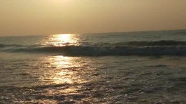 Renkli kış gündoğumu. Soğuk fırtınalı dalgalar ve Baltık Denizi üzerindeki bulutlar manzara videosunda. Tropikal bir plajda romantik bir gün doğumu, kırmızı renkli altın ışınlar. Okyanus dalgaları ve okyanus dalgalarıyla romantik günbatımı. Sabahın erken saatlerinde deniz kıyısında 