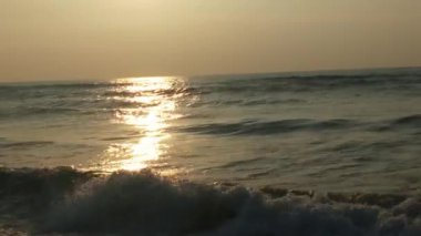 Sabahın erken saatlerinde deniz kıyısında, mavi dalgalar akıyor. Renkli kış gündoğumu. Soğuk fırtınalı dalgalar ve Baltık Denizi üzerindeki bulutlar, yere vuran altın deniz dalgaları. Okyanus manzarası dalgaları dalgalar dalgalar dalgalar deniz dalgaları