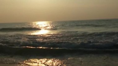 Sabahın erken saatlerinde deniz kıyısında, mavi dalgalar akıyor. Renkli kış gündoğumu. Soğuk fırtınalı dalgalar ve Baltık Denizi üzerindeki bulutlar, yere vuran altın deniz dalgaları. Okyanus manzarası dalgaları dalgalar dalgalar dalgalar deniz dalgaları