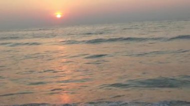 Sabahın erken saatlerinde deniz kıyısında, mavi dalgalar akıyor. Renkli kış gündoğumu. Soğuk fırtınalı dalgalar ve Baltık Denizi üzerindeki bulutlar, yere vuran altın deniz dalgaları. Okyanus manzarası dalgaları dalgalar dalgalar dalgalar deniz dalgaları