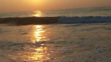 Horizon Sunrise plajında güzel bir gün doğumu. Okyanus ve altın güneş doğuyor, parlak altın arka plan. Güneşin batışında dramatik bulutlu gökyüzünün olduğu güzel manzara. Turuncu gün batımı, teknenin gölgesini denizdeki balıkçıyla vurdu. 