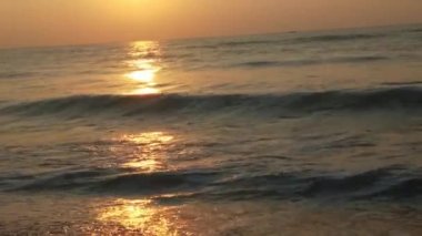 Horizon Sunrise plajında güzel bir gün doğumu. Okyanus ve altın güneş doğuyor, parlak altın arka plan. Güneşin batışında dramatik bulutlu gökyüzünün olduğu güzel manzara. Turuncu gün batımı, teknenin gölgesini denizdeki balıkçıyla vurdu. 