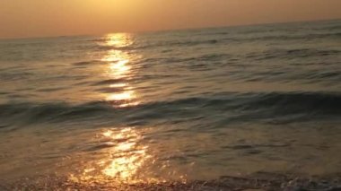 Horizon Sunrise plajında güzel bir gün doğumu. Okyanus ve altın güneş doğuyor, parlak altın arka plan. Güneşin batışında dramatik bulutlu gökyüzünün olduğu güzel manzara. Turuncu gün batımı, teknenin gölgesini denizdeki balıkçıyla vurdu. 