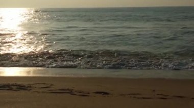 Horizon Sunrise plajında güzel bir gün doğumu. Okyanus ve altın güneş doğuyor, parlak altın arka plan. Güneşin batışında dramatik bulutlu gökyüzünün olduğu güzel manzara. Turuncu gün batımı, teknenin gölgesini denizdeki balıkçıyla vurdu. 