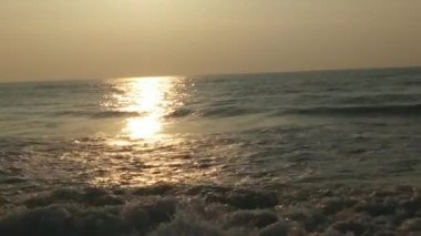 Horizon Sunrise plajında güzel bir gün doğumu. Okyanus ve altın güneş doğuyor, parlak altın arka plan. Güneşin batışında dramatik bulutlu gökyüzünün olduğu güzel manzara. turuncu gün batımı. Fırtınalı bulutlu mavi gökyüzü ile güzel bir video. 