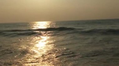 Horizon Sunrise plajında güzel bir gün doğumu. Okyanus ve altın güneş doğuyor, parlak altın arka plan. Güneşin batışında dramatik bulutlu gökyüzünün olduğu güzel manzara. turuncu gün batımı. Fırtınalı bulutlu mavi gökyüzü ile güzel bir video. 