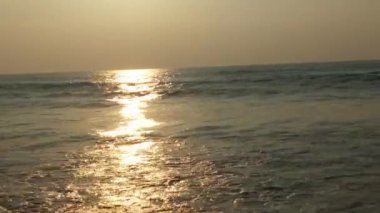 Horizon Sunrise plajında güzel bir gün doğumu. Okyanus ve altın güneş doğuyor, parlak altın arka plan. Güneşin batışında dramatik bulutlu gökyüzünün olduğu güzel manzara. turuncu gün batımı. Fırtınalı bulutlu mavi gökyüzü ile güzel bir video. 