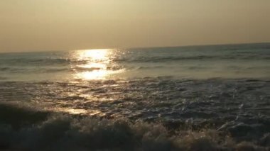 Horizon Sunrise plajında güzel bir gün doğumu. Okyanus ve altın güneş doğuyor, parlak altın arka plan. Güneşin batışında dramatik bulutlu gökyüzünün olduğu güzel manzara. turuncu gün batımı. Fırtınalı bulutlu mavi gökyüzü ile güzel bir video. 