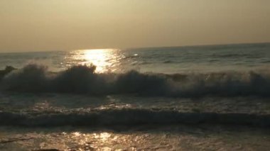 Güneşin doğuşunda balıkçıyla birlikte teknenin silueti Horizon Sunrise sahilinde güzel bir gün doğumu. Okyanus ve altın güneş doğuyor, parlak altın arka plan. Güneşin batışında dramatik bulutlu gökyüzünün olduğu güzel manzara. turuncu 