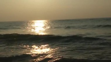 Güneşin doğuşunda balıkçıyla birlikte teknenin silueti Horizon Sunrise sahilinde güzel bir gün doğumu. Okyanus ve altın güneş doğuyor, parlak altın arka plan. Güneşin batışında dramatik bulutlu gökyüzünün olduğu güzel manzara. turuncu 