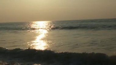 Güneşin doğuşunda balıkçıyla birlikte teknenin silueti Horizon Sunrise sahilinde güzel bir gün doğumu. Okyanus ve altın güneş doğuyor, parlak altın arka plan. Güneşin batışında dramatik bulutlu gökyüzünün olduğu güzel manzara. turuncu 