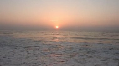 Atlantik Okyanusu üzerinde gün doğumu, okyanus dalgaları bir manzara hareketi. Denizin ve doğanın kıyılarının videosu. Renkli kış gündoğumu. Soğuk fırtınalı dalgalar ve Baltık Denizi üzerindeki bulutlar manzara videosunda. Tropikal bir sahilde romantik bir gün doğumu.  