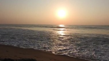 Atlantik Okyanusu üzerinde gün doğumu, okyanus dalgaları bir manzara hareketi. Denizin ve doğanın kıyılarının videosu. Renkli kış gündoğumu. Soğuk fırtınalı dalgalar ve Baltık Denizi üzerindeki bulutlar manzara videosunda. Tropikal bir sahilde romantik bir gün doğumu.  