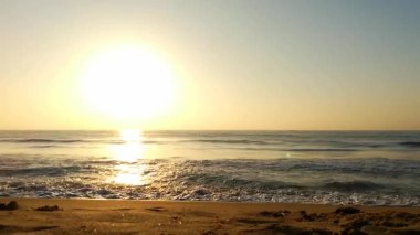 Sabahın erken saatlerinde deniz kıyısında, mavi dalgalar akıyor. Renkli kış gündoğumu. Soğuk fırtınalı dalgalar ve Baltık Denizi üzerindeki bulutlar, yere vuran altın deniz dalgaları. Okyanus manzarası dalgaları dalgalar dalgalar dalgalar deniz dalgaları