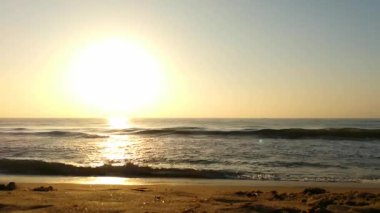 Sabahın erken saatlerinde deniz kıyısında, mavi dalgalar akıyor. Renkli kış gündoğumu. Soğuk fırtınalı dalgalar ve Baltık Denizi üzerindeki bulutlar, yere vuran altın deniz dalgaları. Okyanus manzarası dalgaları dalgalar dalgalar dalgalar deniz dalgaları